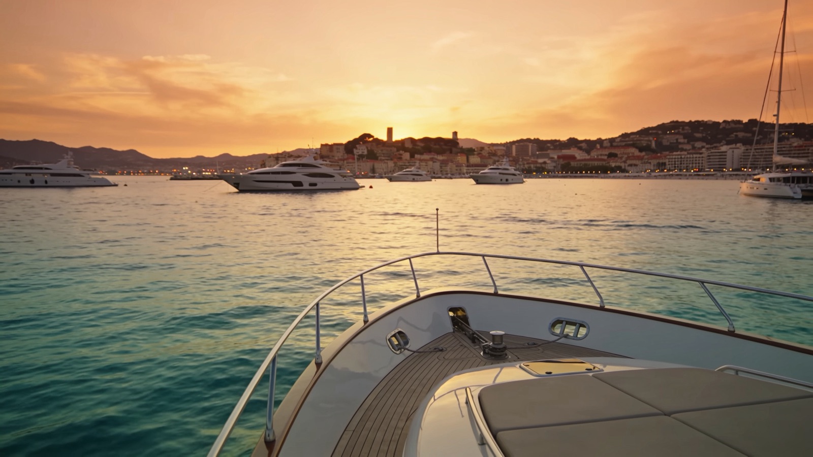 Vista de la bahía de Cannes y los yates fondeados desde un barco privado al atardecer.